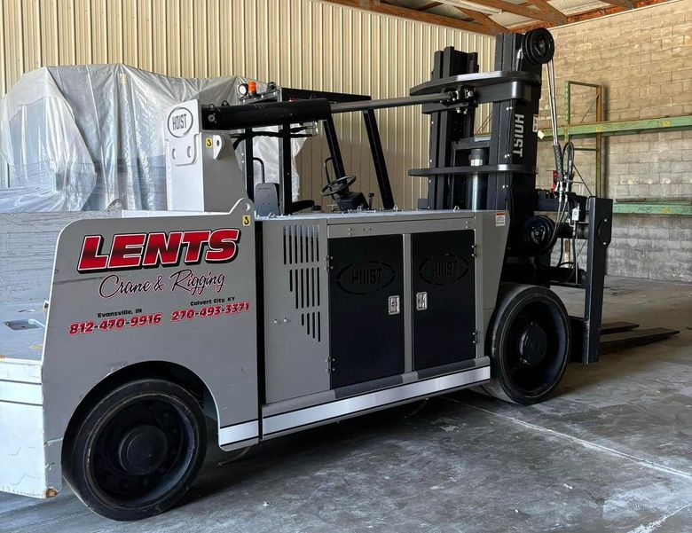 A forklift is parked in a warehouse with the word lewis on the side