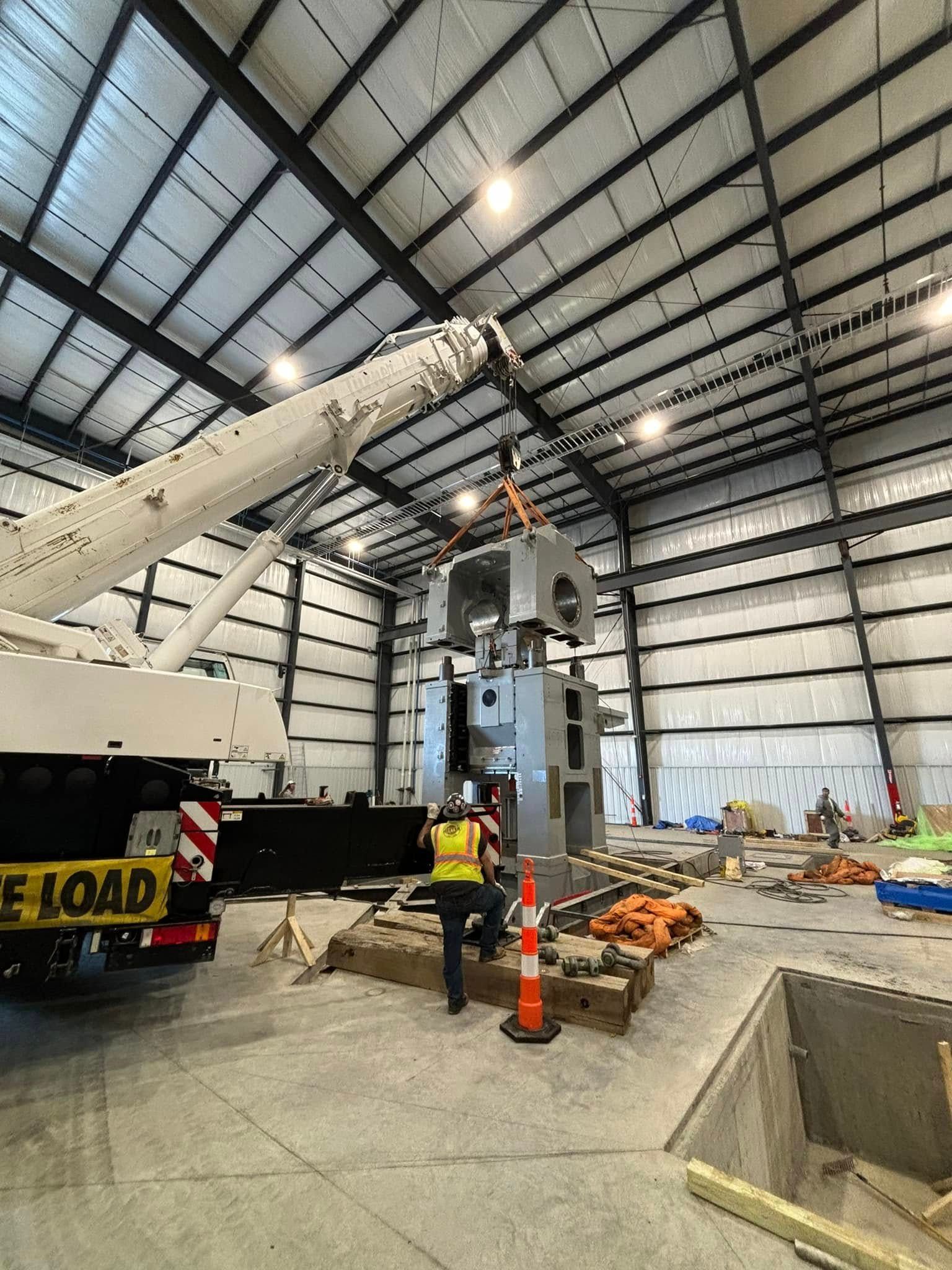 A crane is being used to lift a large object in a large building.