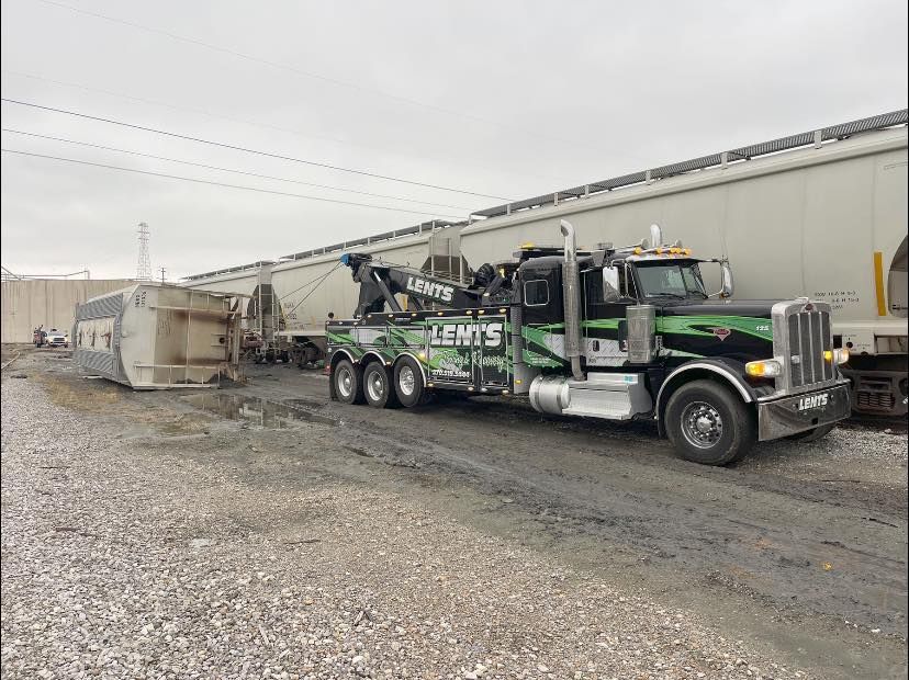 A tow truck is parked next to a train car.