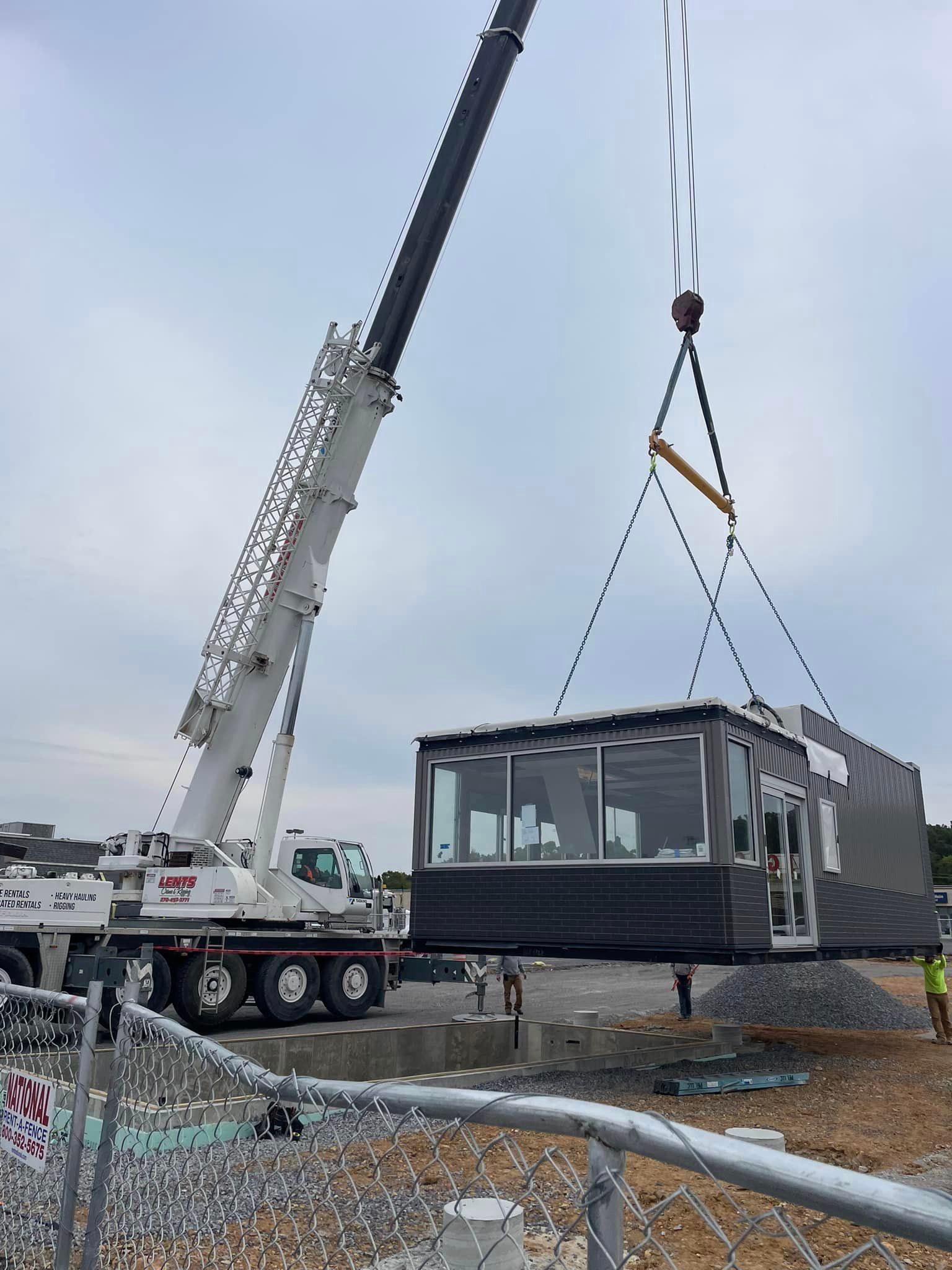 A crane is lifting a building into the air.