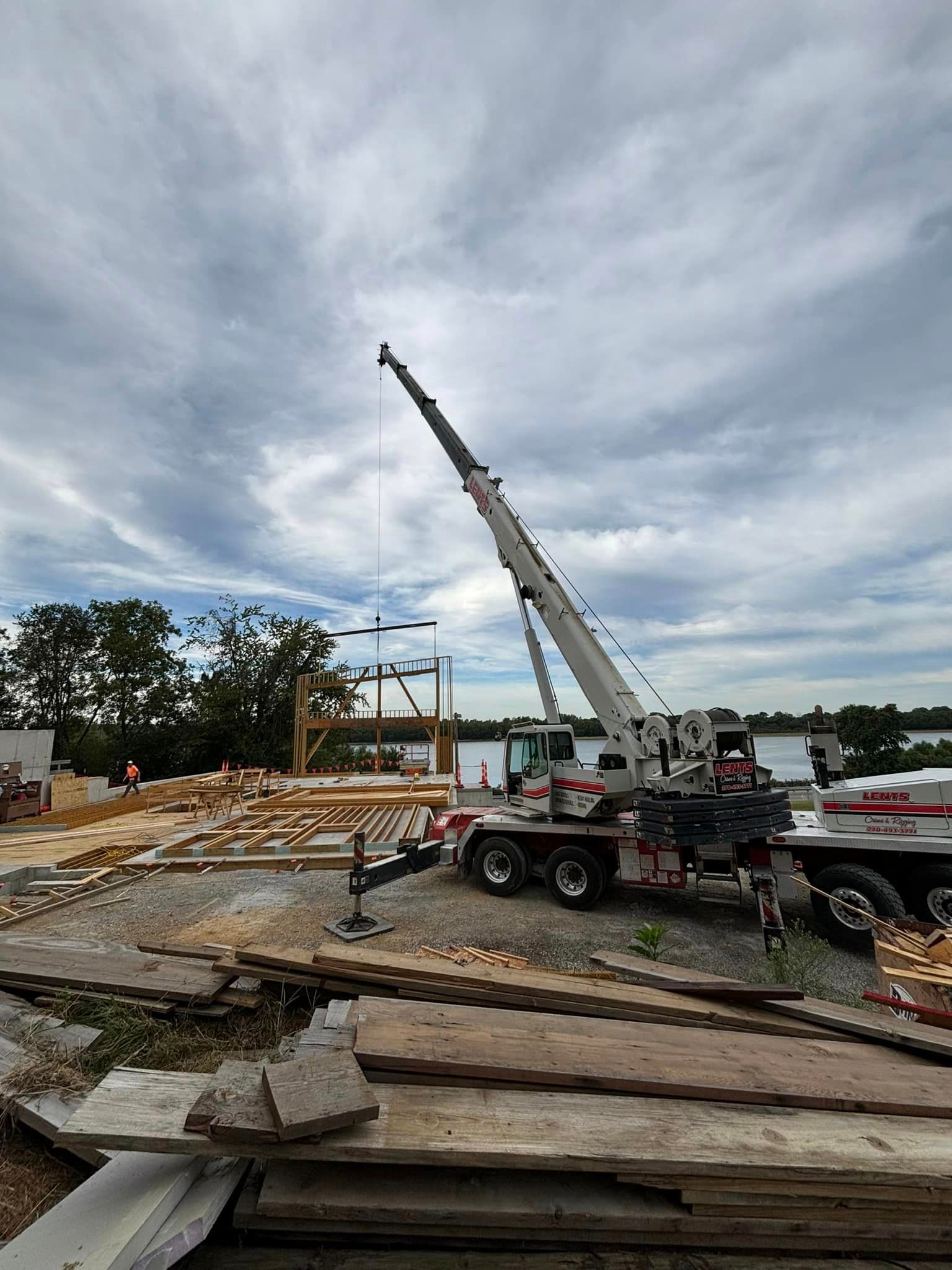 A large crane is sitting on top of a pile of wood.