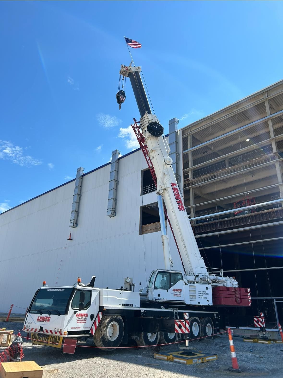 A large crane is parked in front of a building under construction.