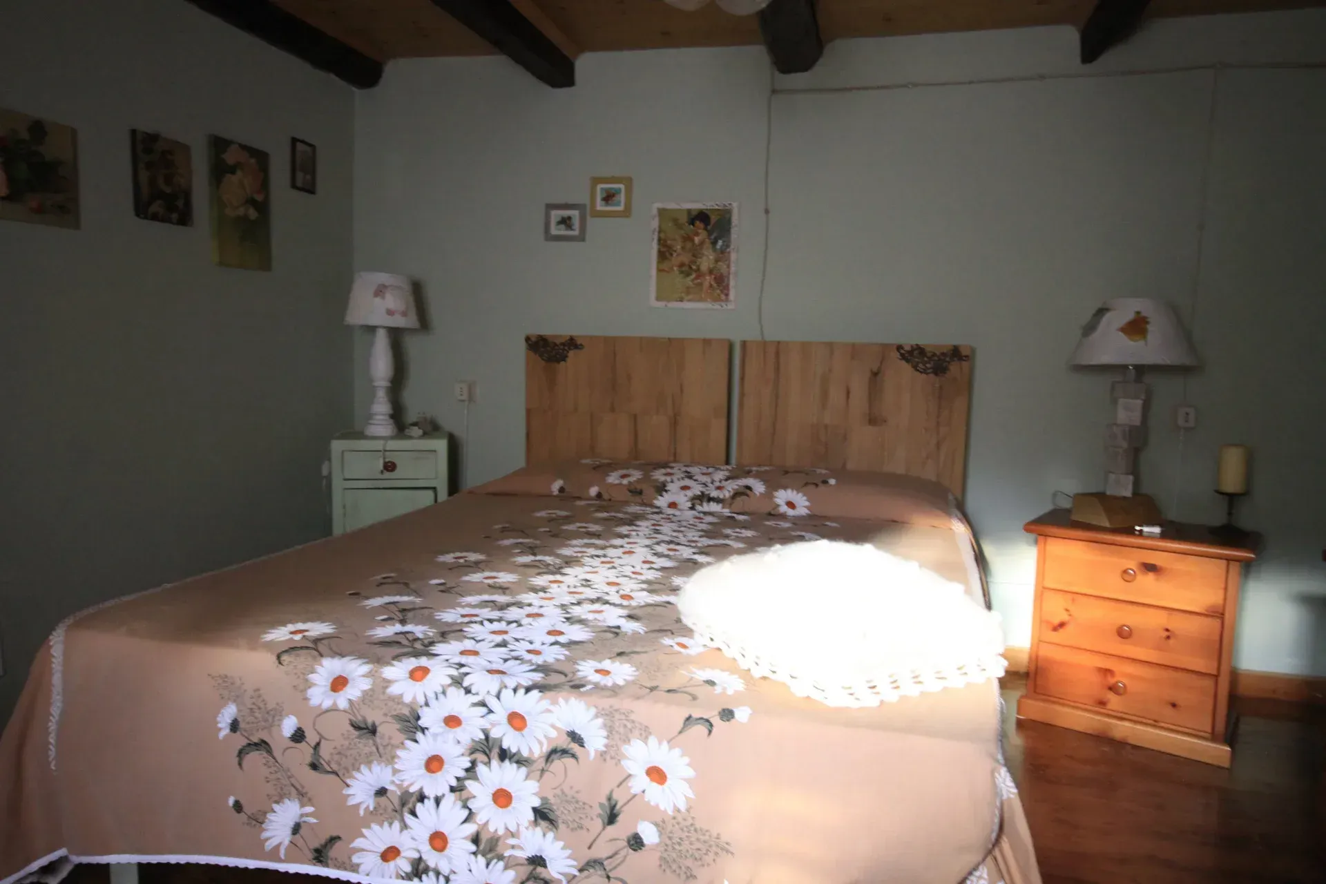 Camera da letto con letto ricoperto da un piumone floreale, affiancato da comodini e lampade