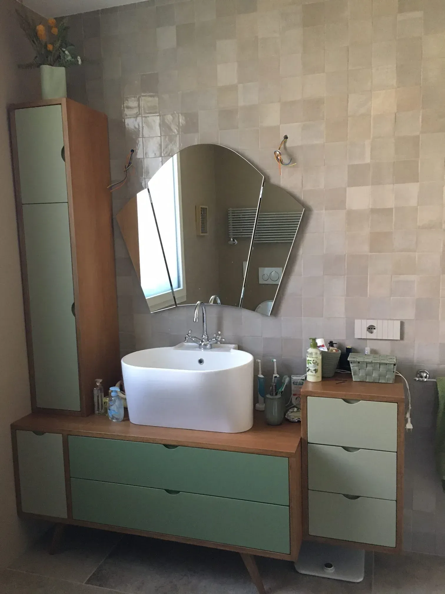 Mobile bagno con mobili verdi, lavandino bianco e specchio esclusivo.