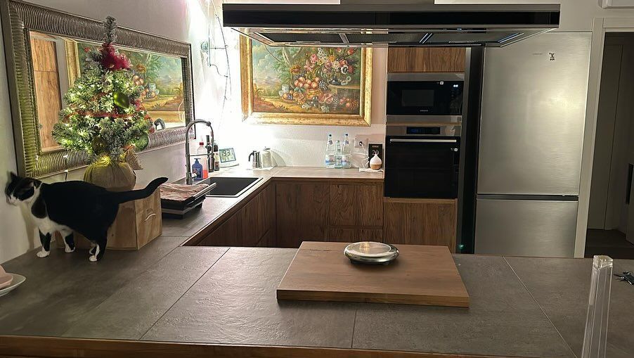 Porta ad arco in legno con tre pannelli di vetro incastonati in un muro di mattoni.