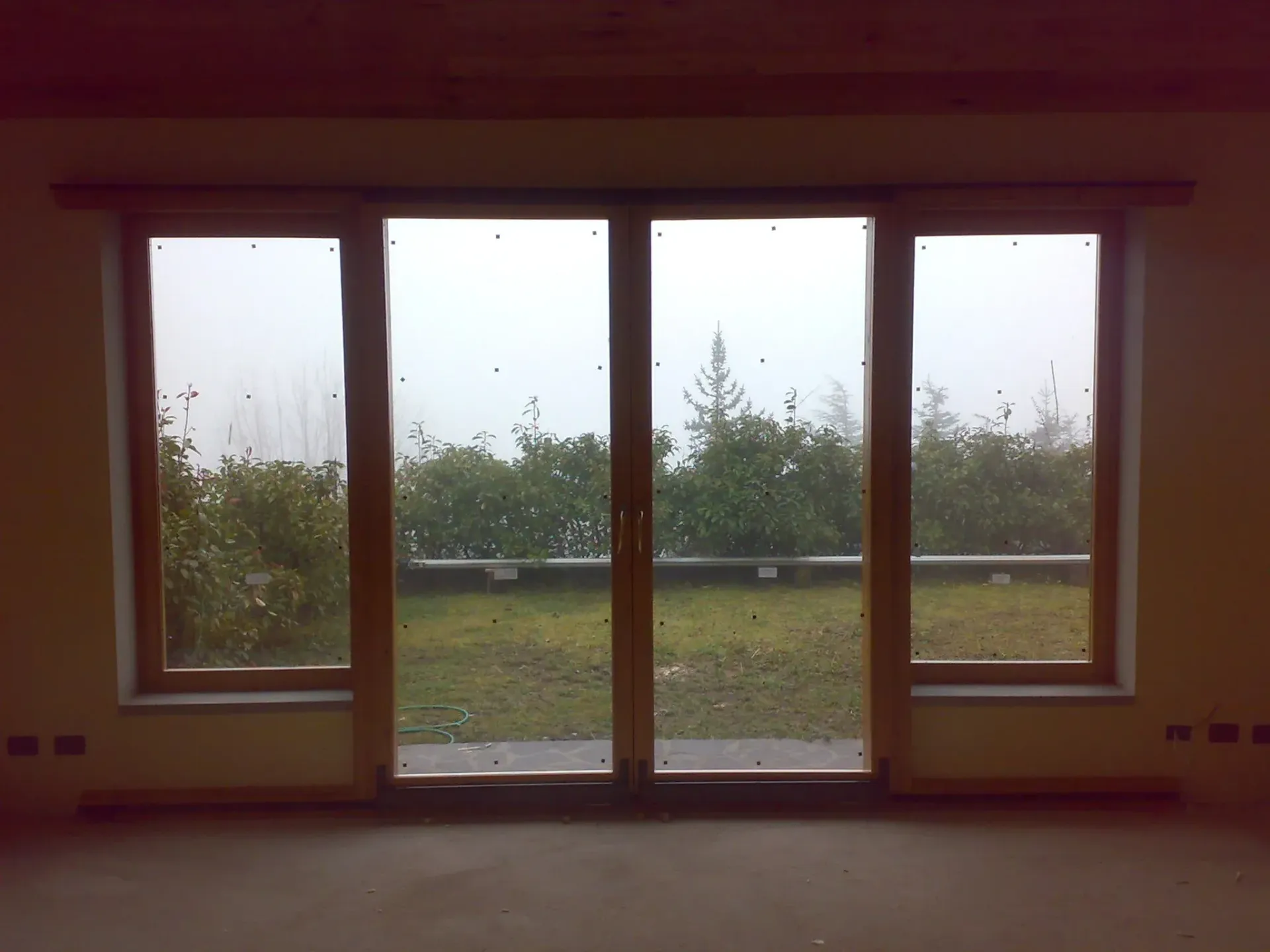 Ampie porte scorrevoli in vetro con cornice in legno