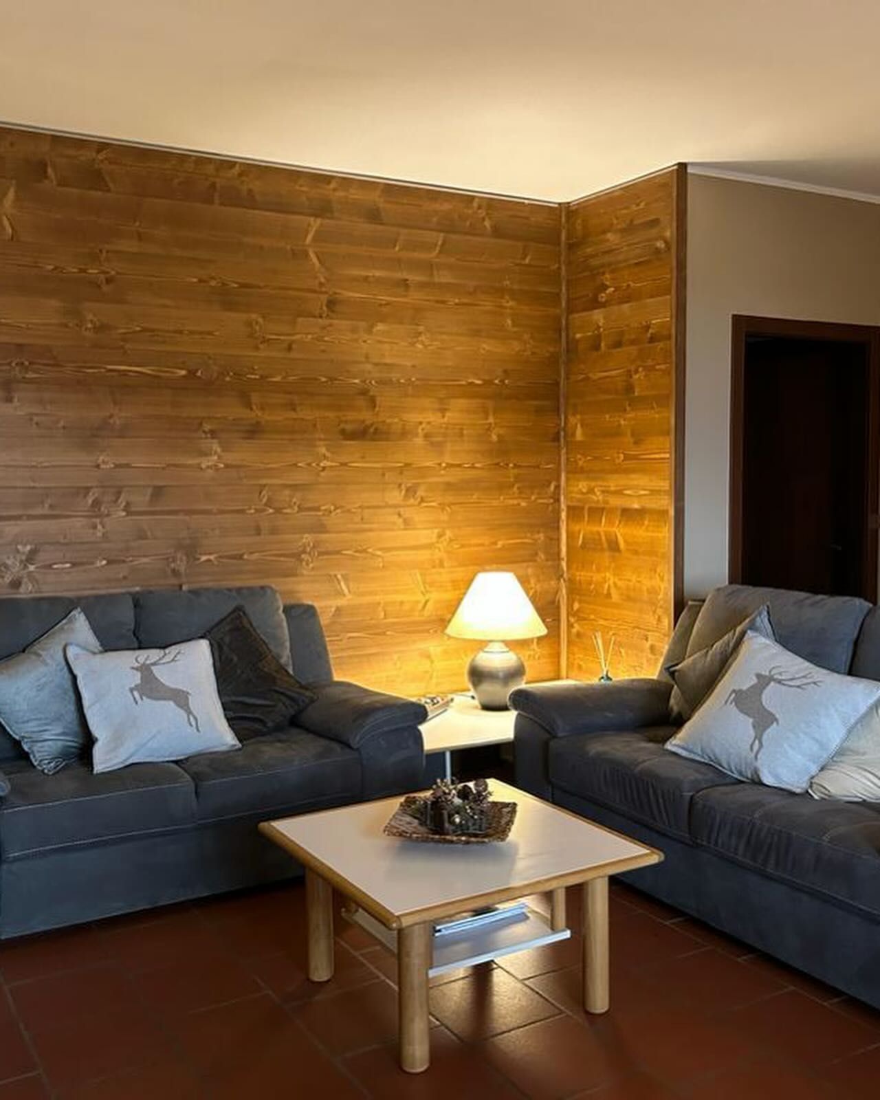 Rifugio in pietra con tetto in legno sopra gradini e tavolo in un ambiente esterno.