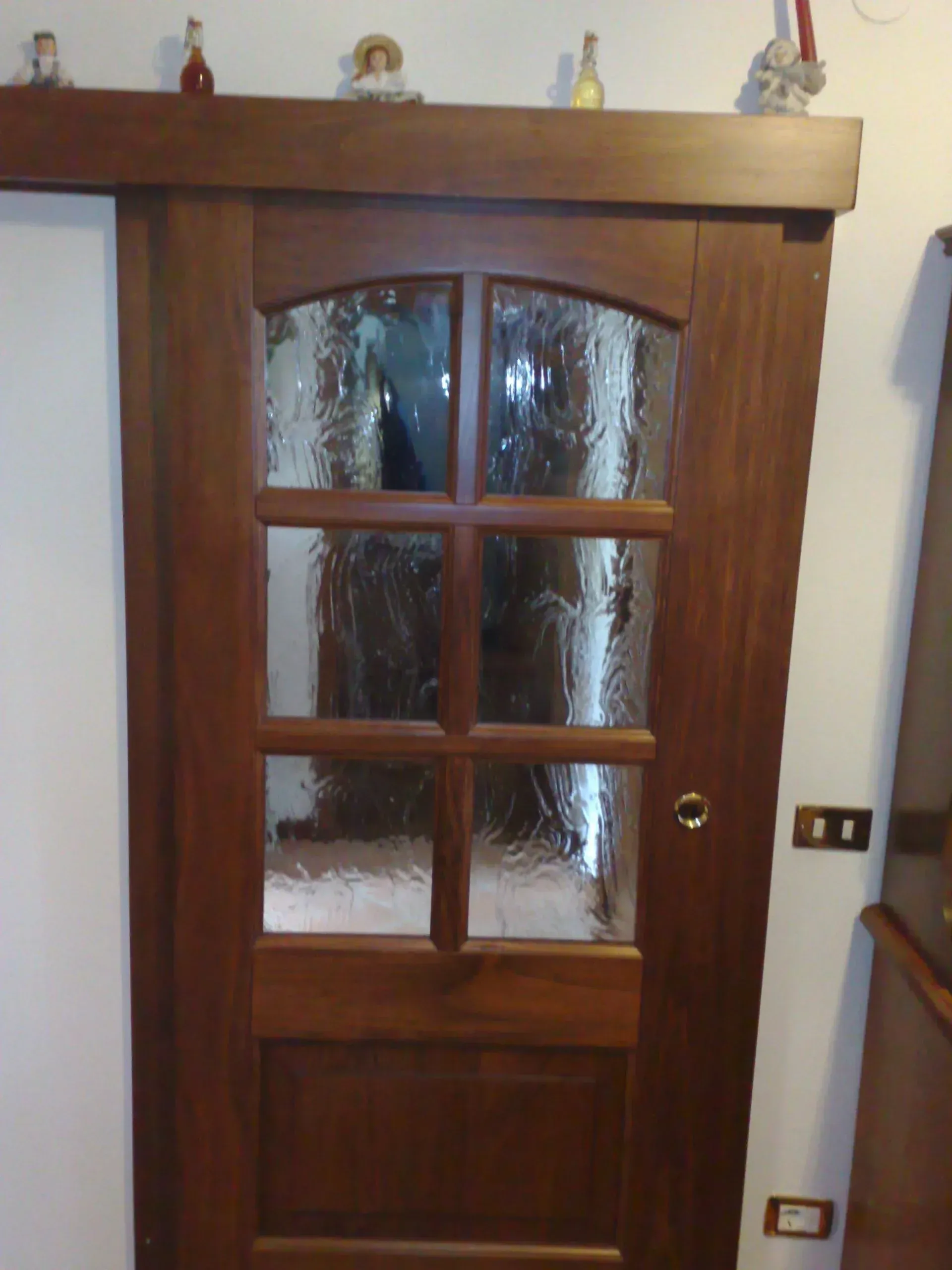 Porta in legno con vetri. Telaio in legno scuro.