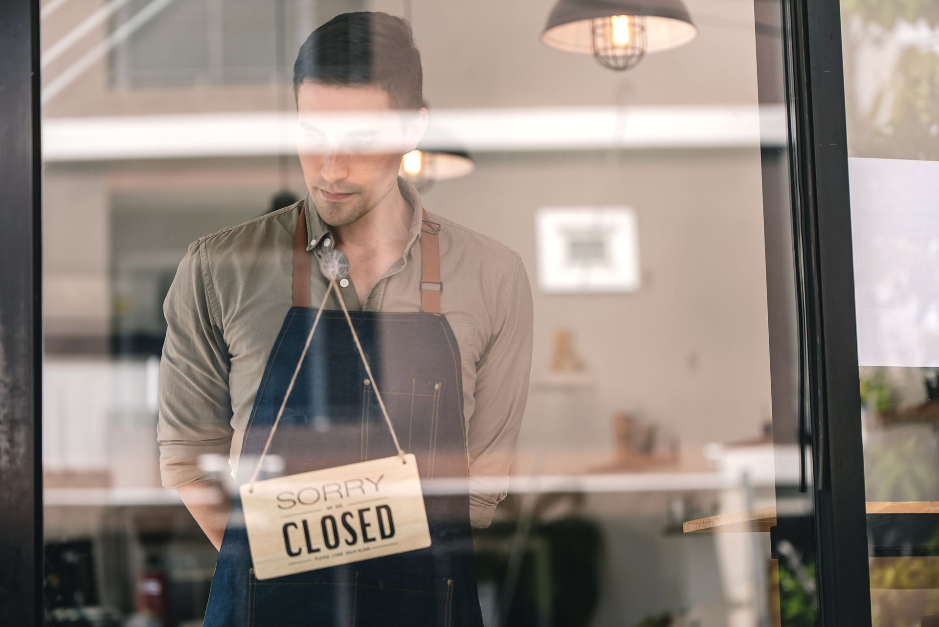 Two men are standing in a kitchen talking to each other.