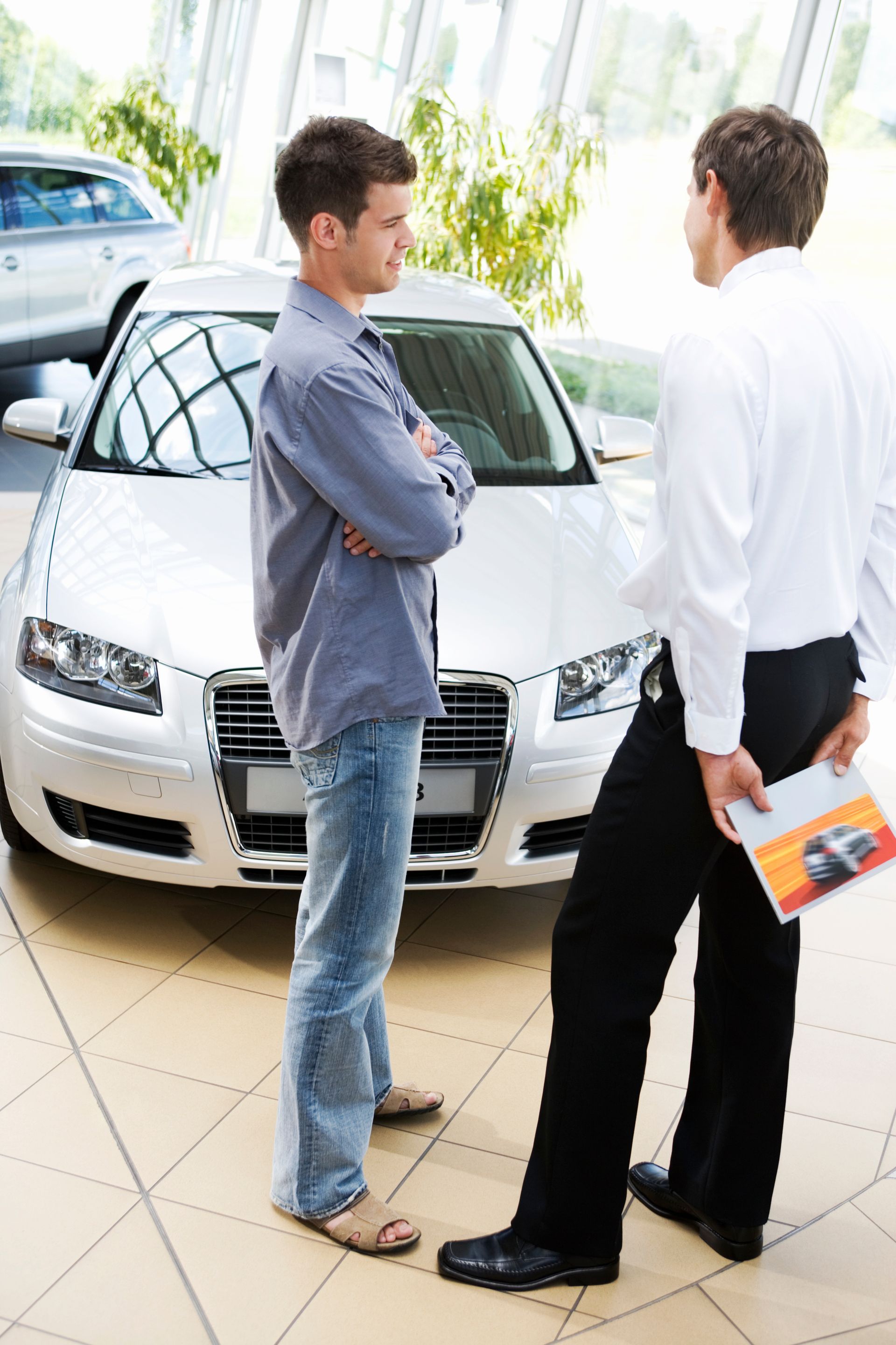 A man and a woman are sitting on a couch in a living room watching tv.