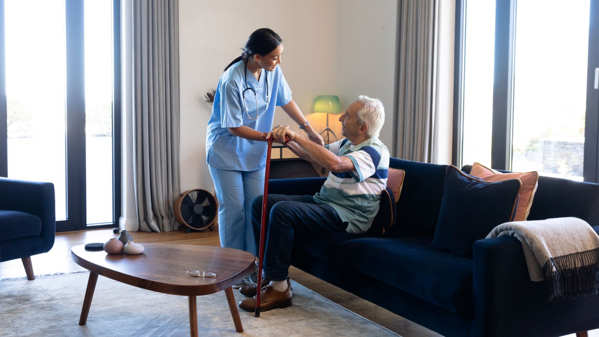 A man and a woman are sitting on a couch in a living room watching tv.