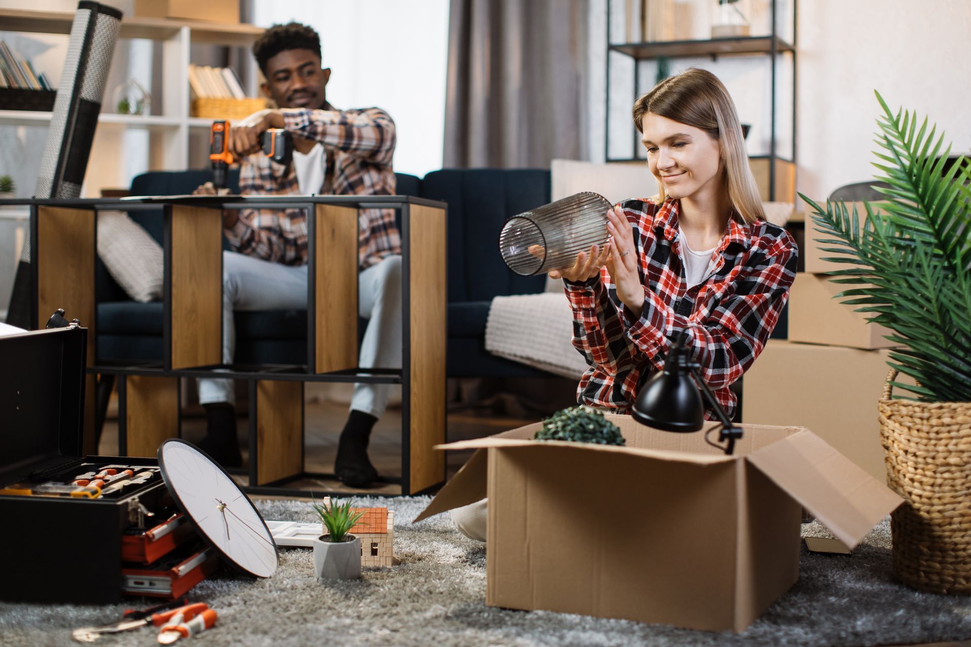 A family is moving into a new home carrying boxes.