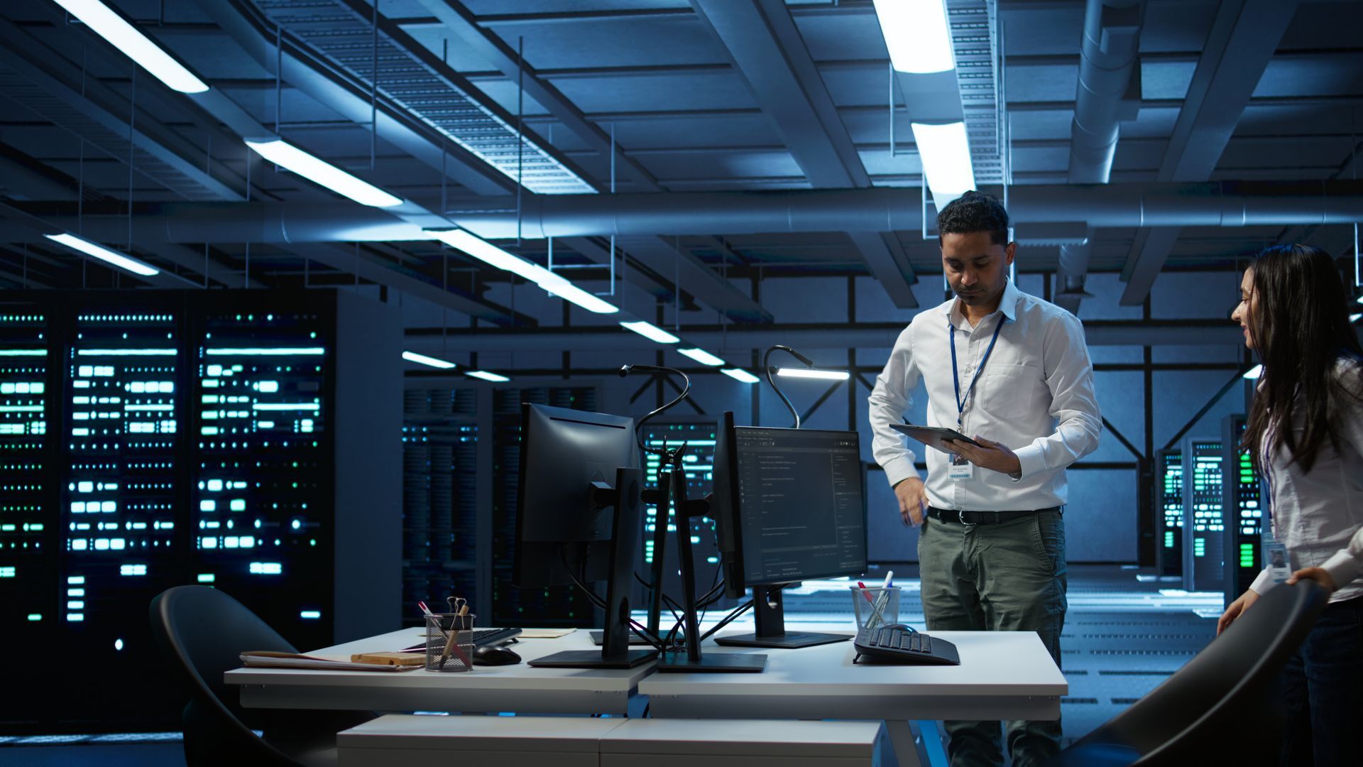 Two men are standing in a kitchen talking to each other.
