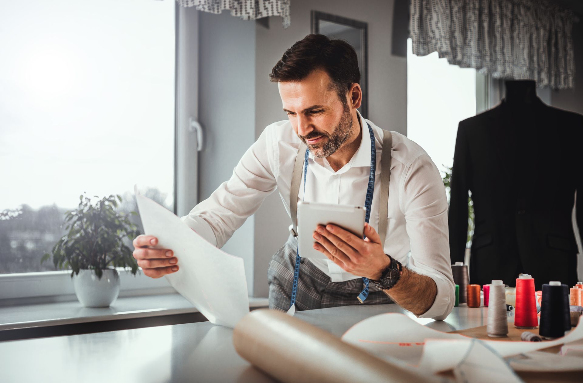 Two men are standing in a kitchen talking to each other.