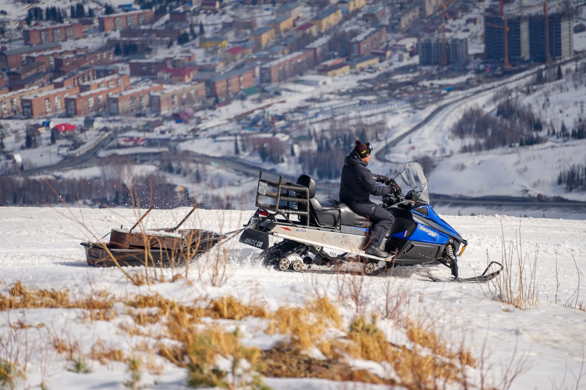 Two men are standing in a kitchen talking to each other.