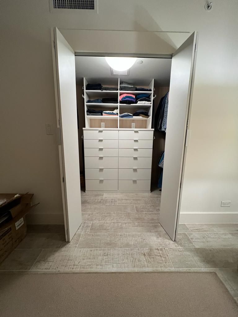 A walk in closet with a lot of clothes in it.