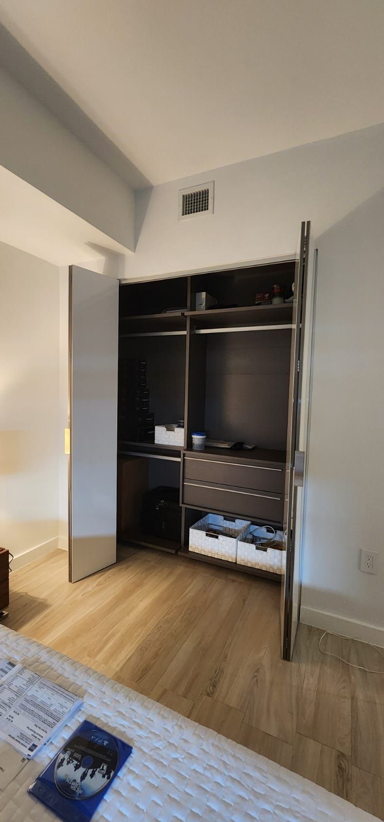 A bedroom with a walk in closet and a bed.