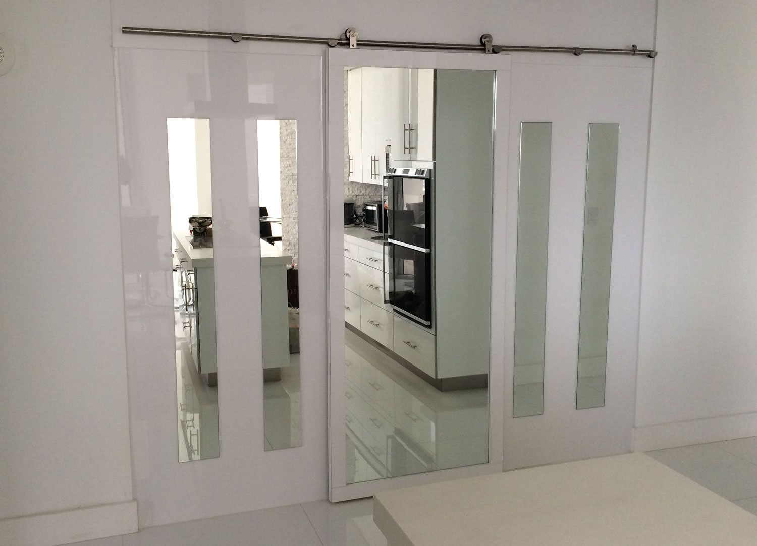 A kitchen with white cabinets and sliding glass doors