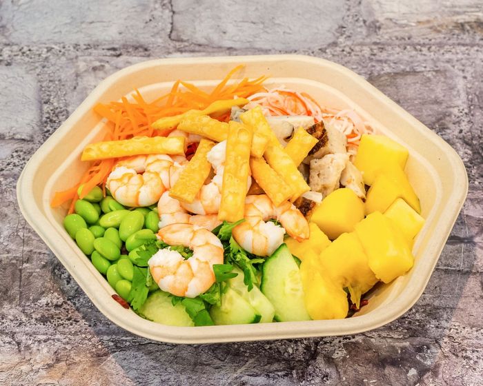 Poke Go's Poke Bowl with shrimp, pineapple, carrots, cucumber, wonton chips in it.