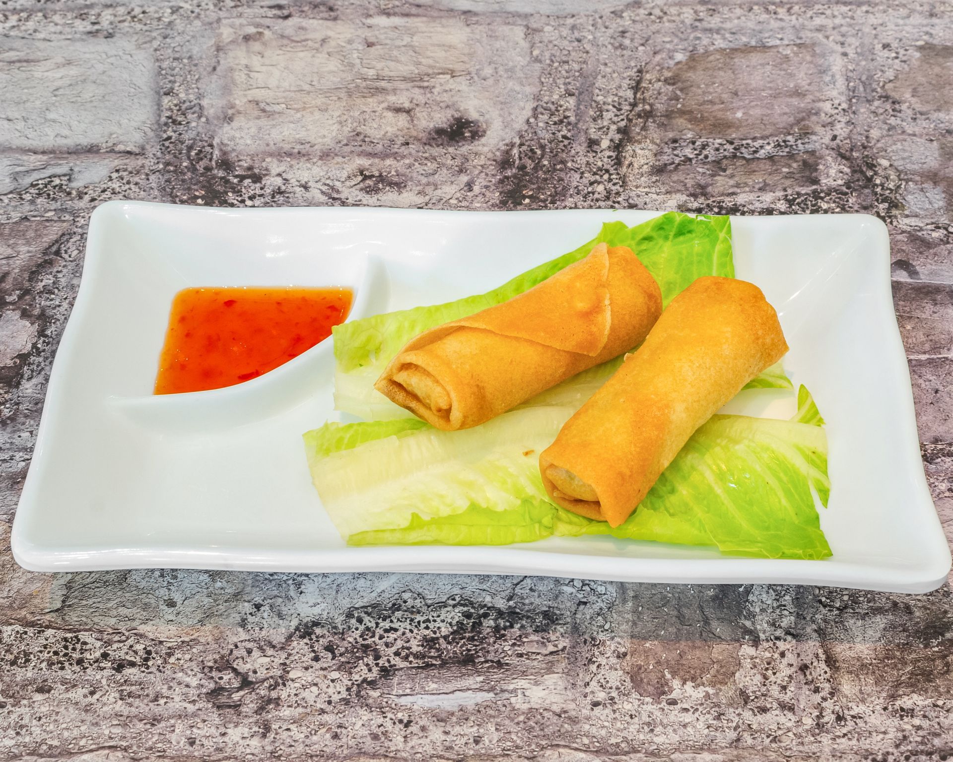Poke Go's 2 spring rolls in a white dish on table