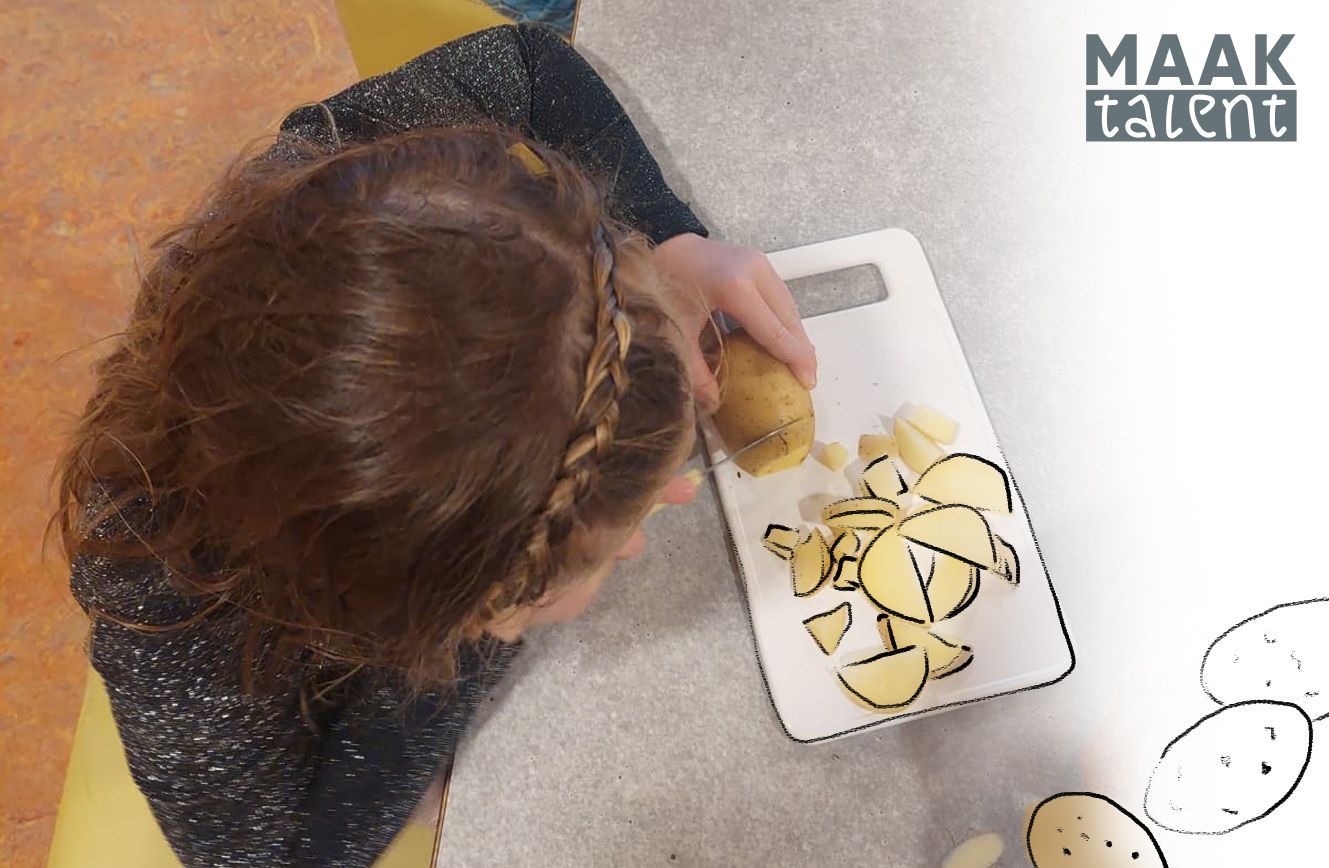 Een aantal kinderen zitten en hangen aan een omgevallen boom.