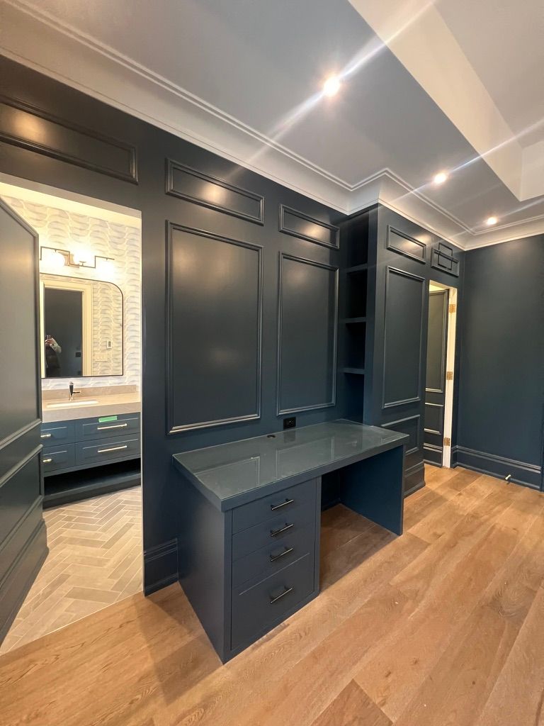 Bright modern lobby with blue double doors, patterned floor, tall windows, and staircase railing