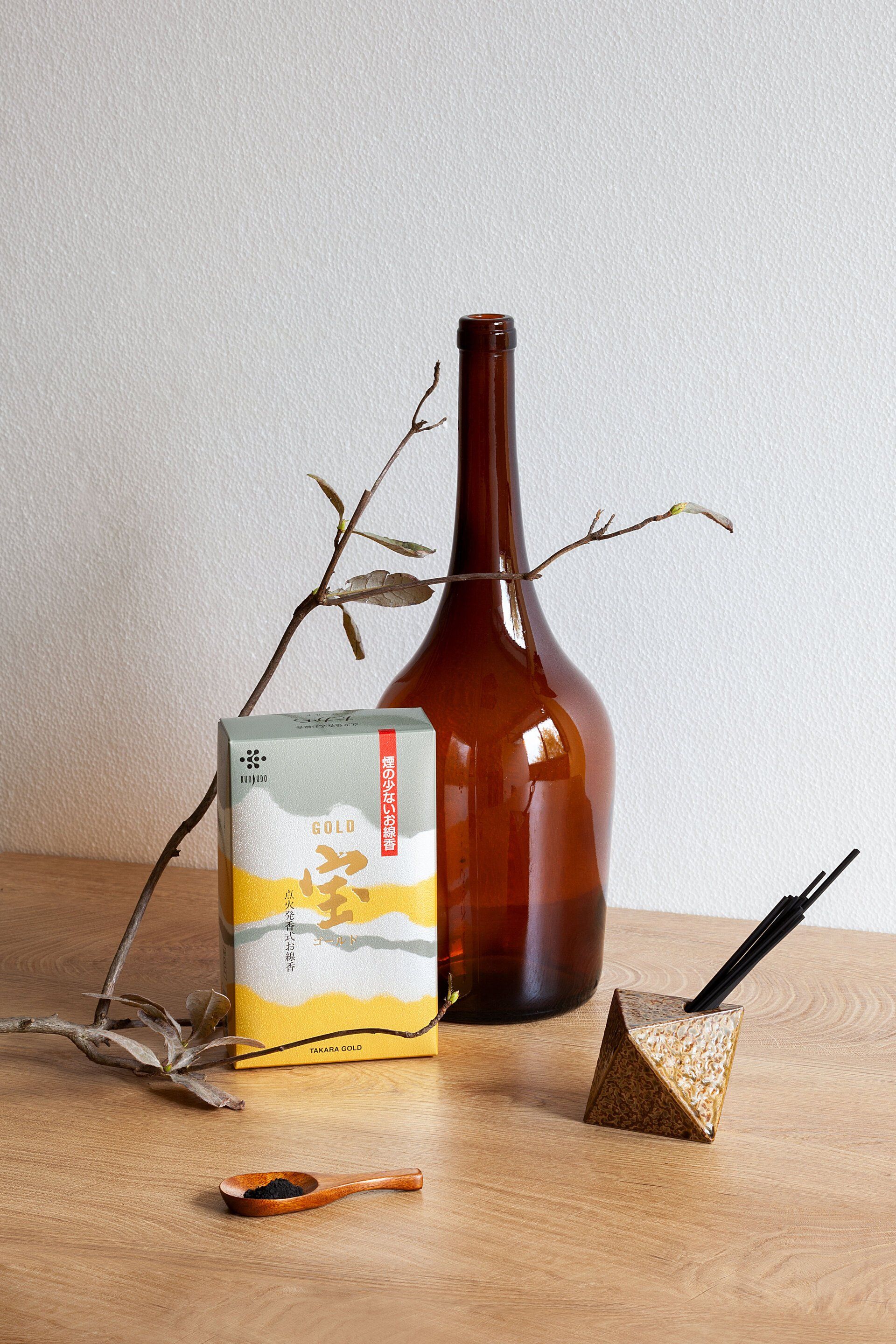 Una bottiglia e una scatola di incenso sono su un tavolo di legno.