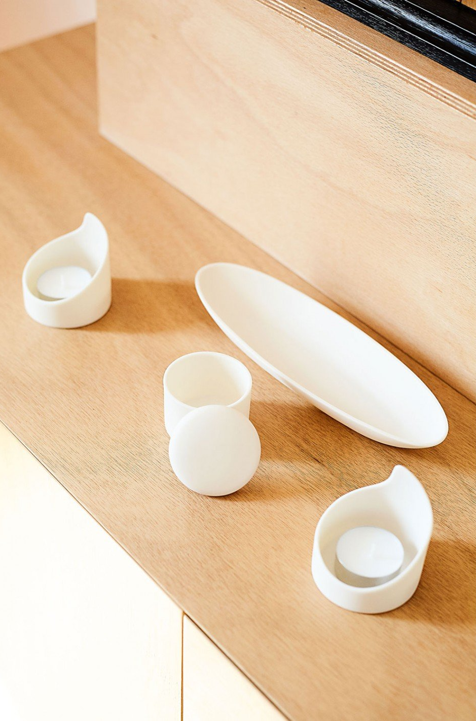 Un tavolo di legno con tre piatti bianchi e tazze sopra