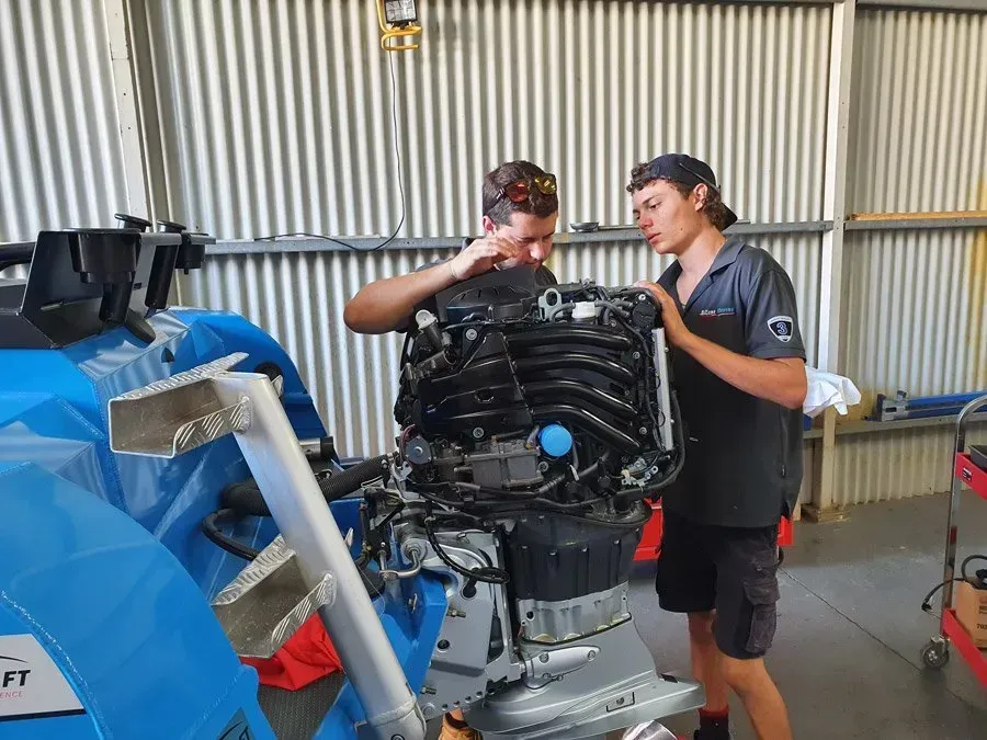 Two People Work on A Boat Engine in A Garage — HiTune Marine In Bentley Park, QLD