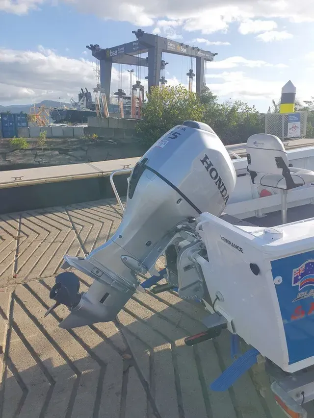 Silver Honda Outboard Motor Attached to A White Boat on A Concrete Dock — HiTune Marine In Bentley Park, QLD 