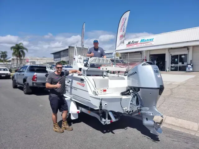 Two Men Beside a White Boat with A Large Outboard Motor in Front of A Building with A Business Sign — HiTune Marine In Bentley Park, QLD 