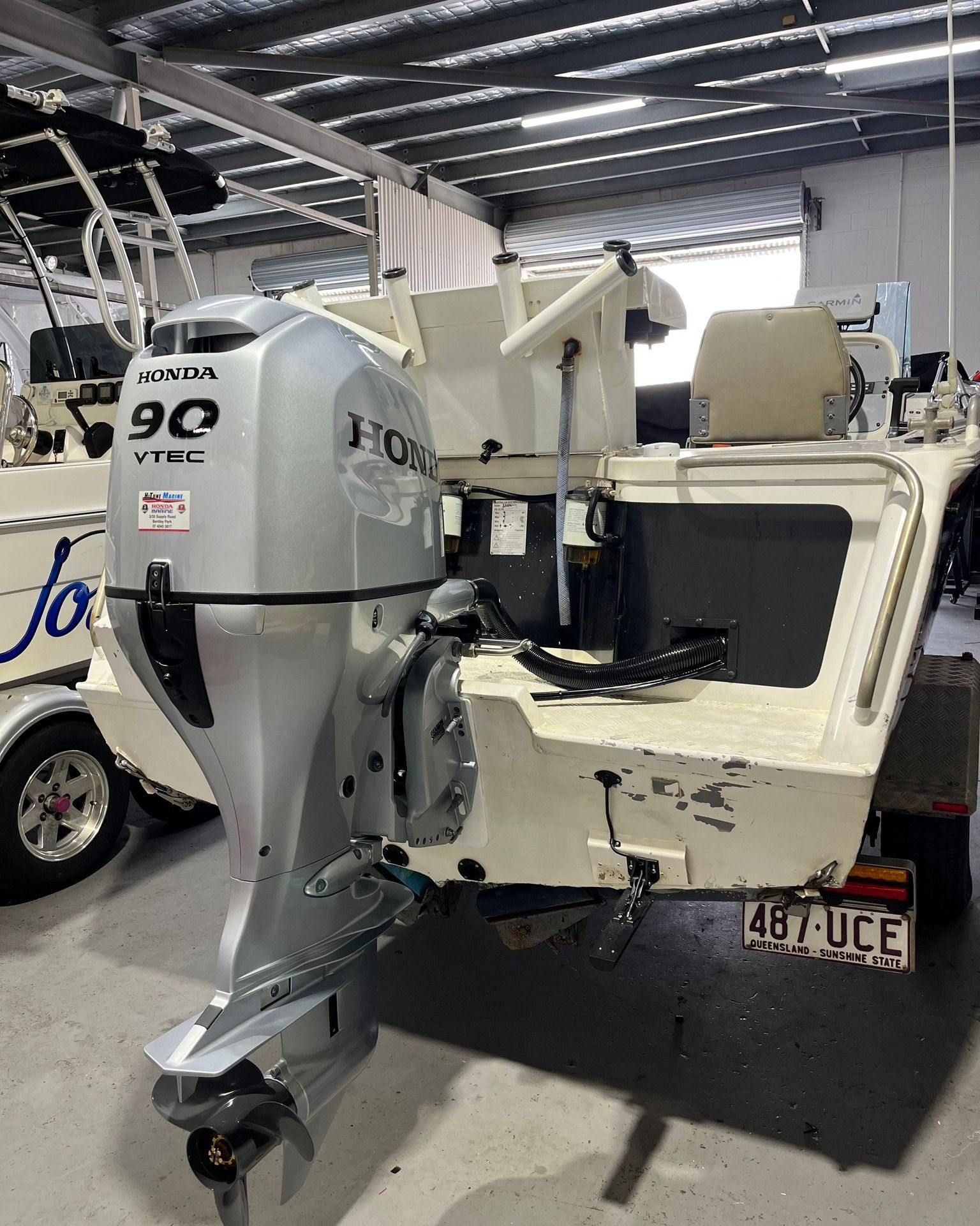 Honda 90 Q Vtec Outboard Motor Attached to A Small White Boat — HiTune Marine In Mossman, QLD 