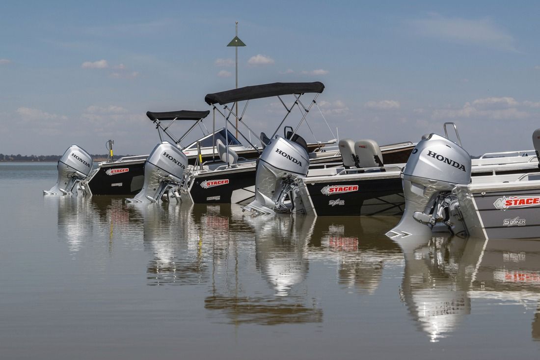 Pontoon Boats with Honda Engines Lined up In Shallow Water — HiTune Marine In Bentley Park, QLD