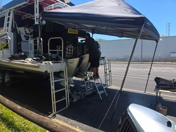 A Person Working on the Engine of a Boat Under a Canopy — HiTune Marine In Bentley Park, QLD 