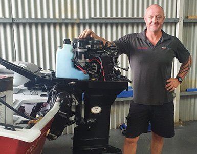 Man with Arm on A Black Outboard Motor, Standing in A Workshop — HiTune Marine In Port Douglas, QLD 