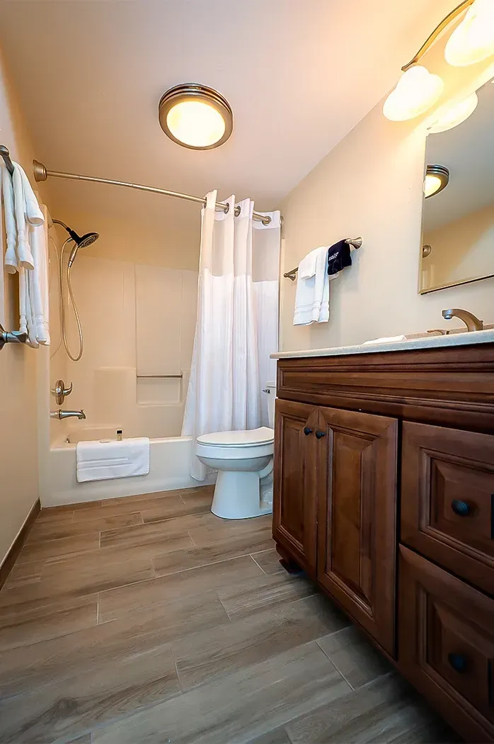 A bathroom with a toilet , sink , tub and shower.