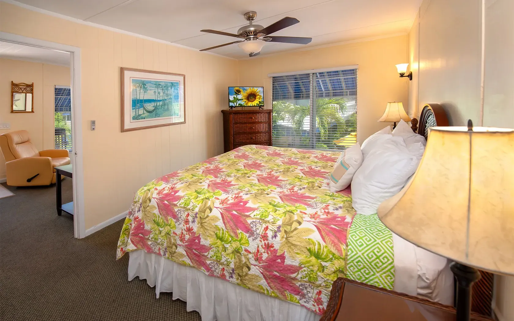 A bedroom with a king size bed and a ceiling fan.