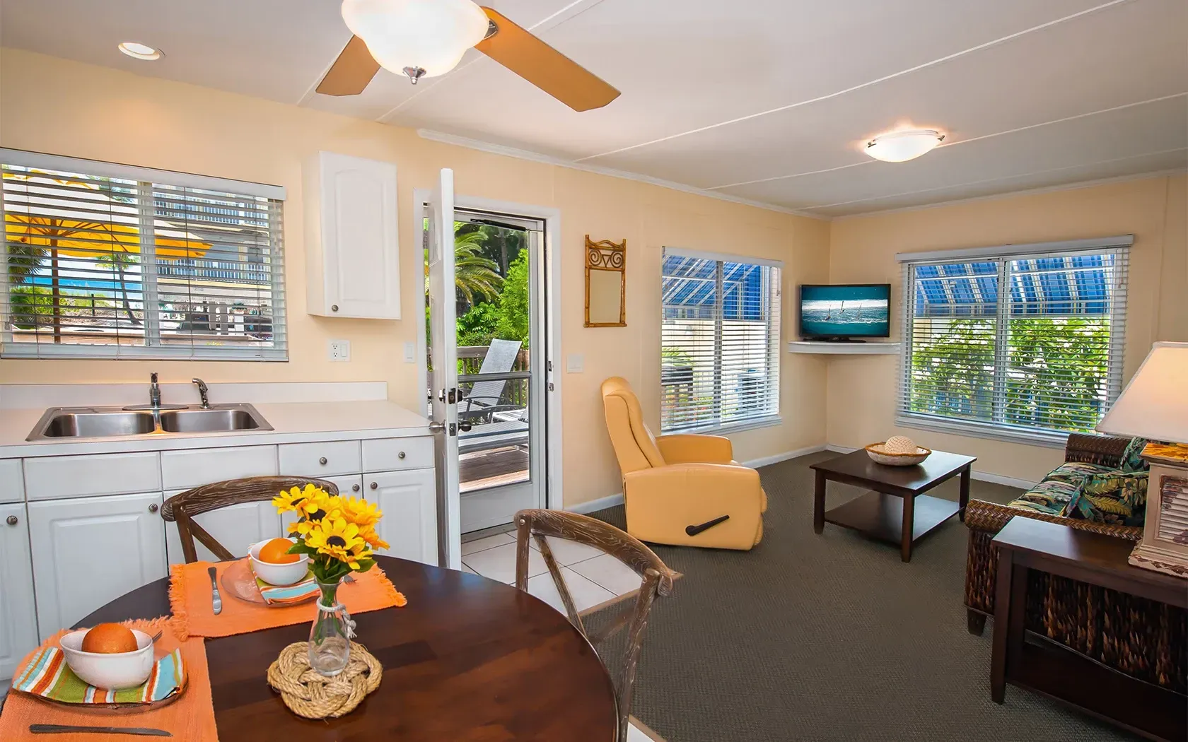 A living room with a table and chairs and a ceiling fan.