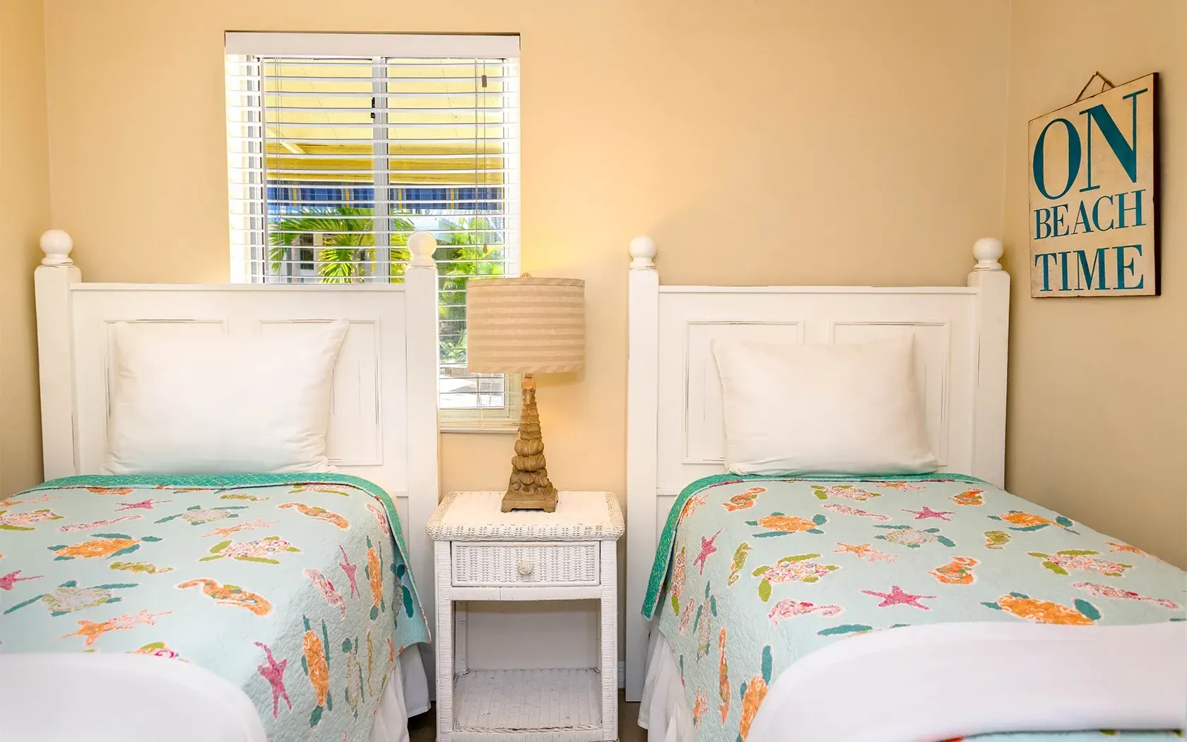 A bedroom with two twin beds , a nightstand and a window.