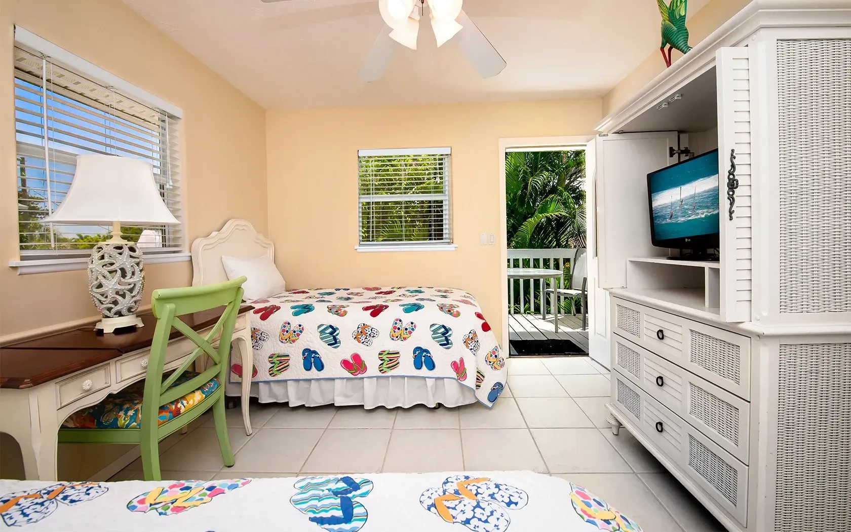 A bedroom with two beds , a desk and a television.