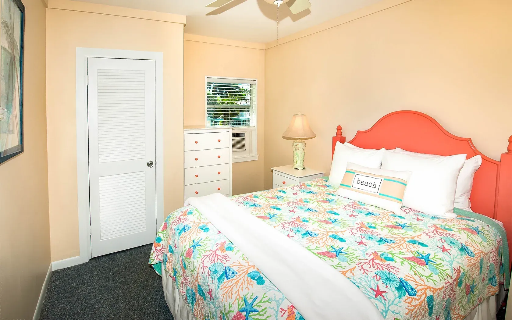 A bedroom with a bed , dresser , nightstand and ceiling fan.