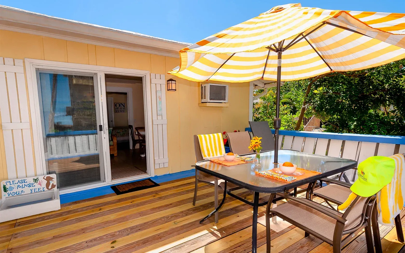 There is a table and chairs on the deck with an umbrella.