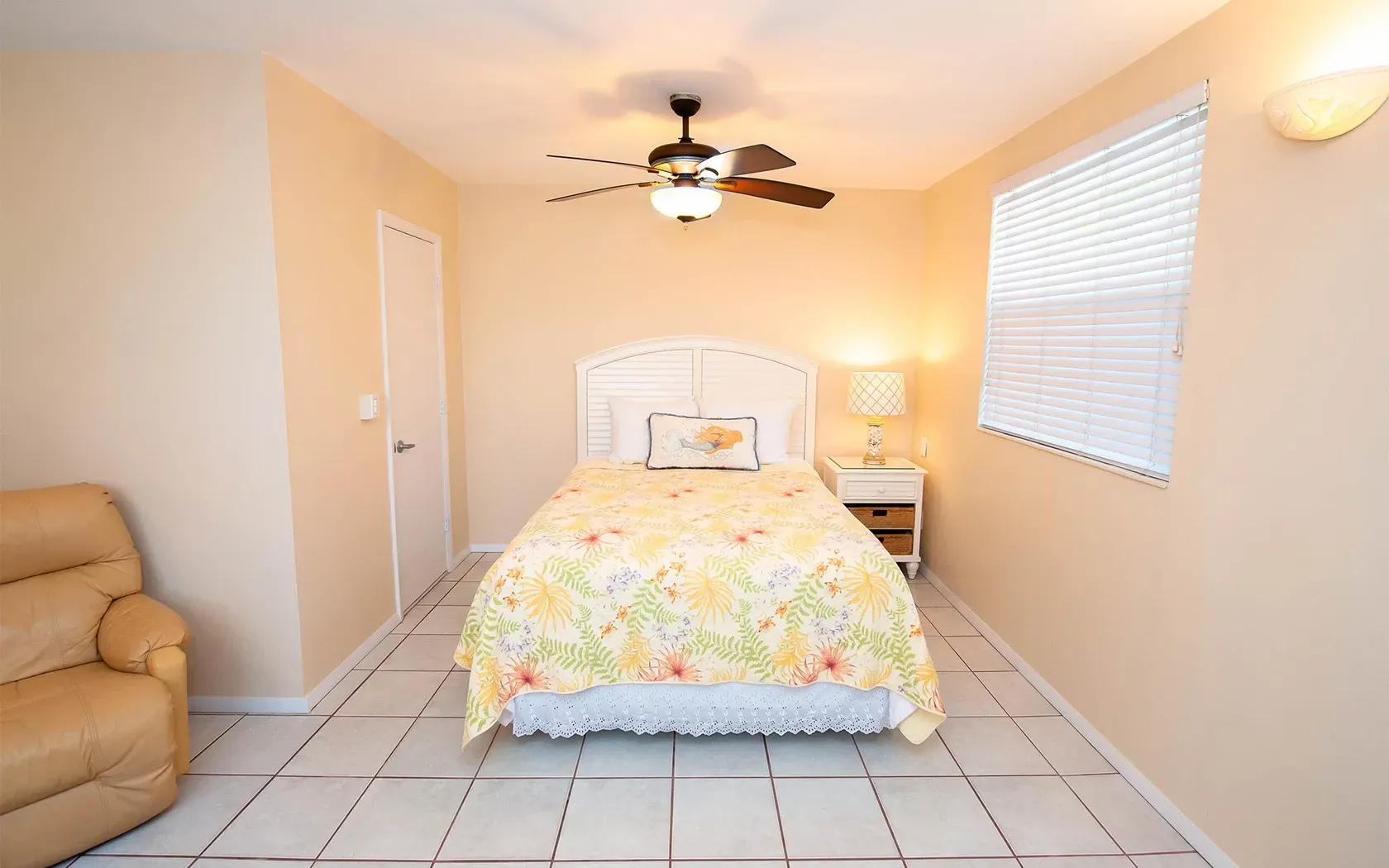 A bedroom with a bed and a ceiling fan