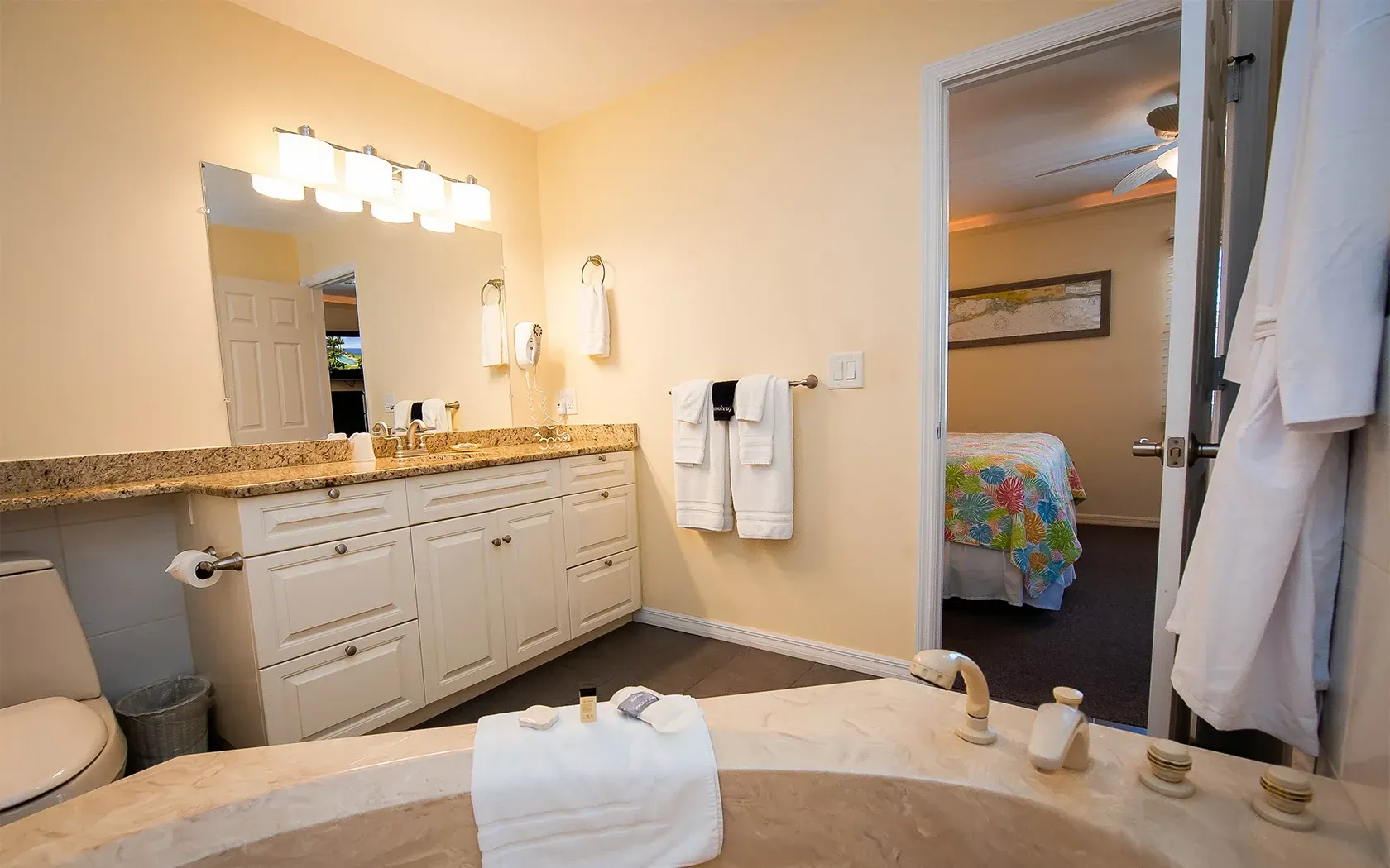 A bathroom with a tub , sink , toilet and mirror.