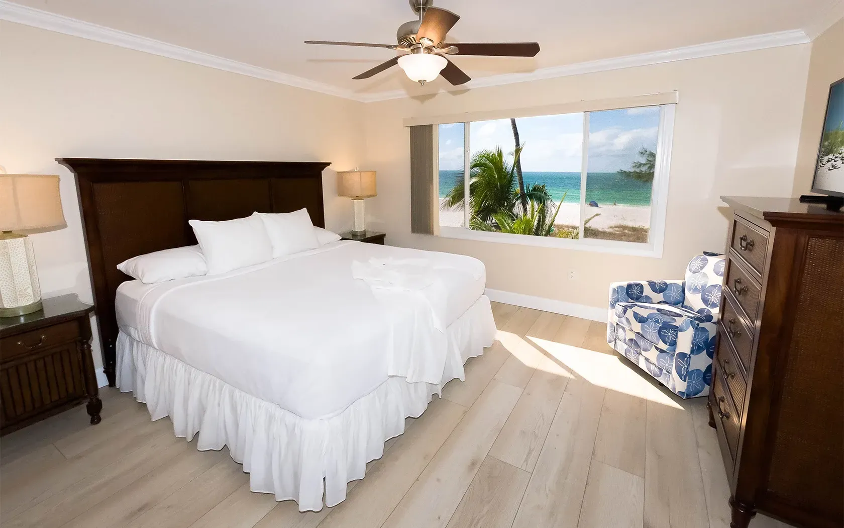 A bedroom with a king size bed and a ceiling fan