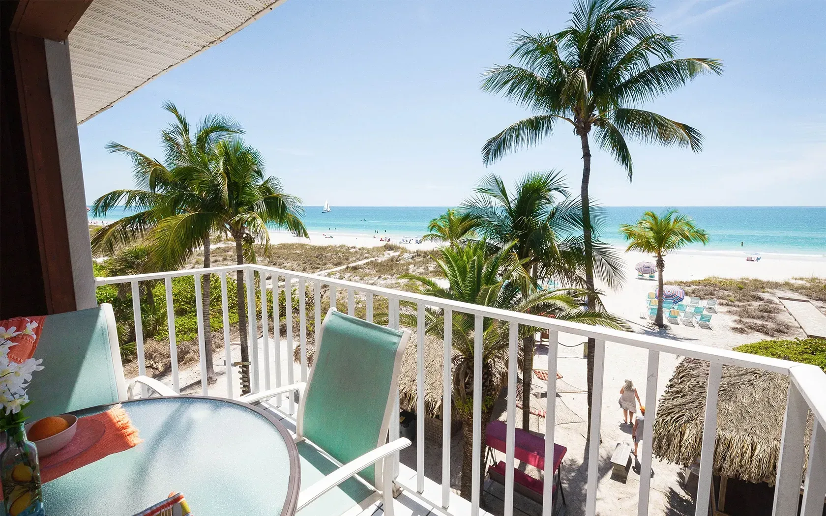 A balcony with a table and chairs overlooking the ocean