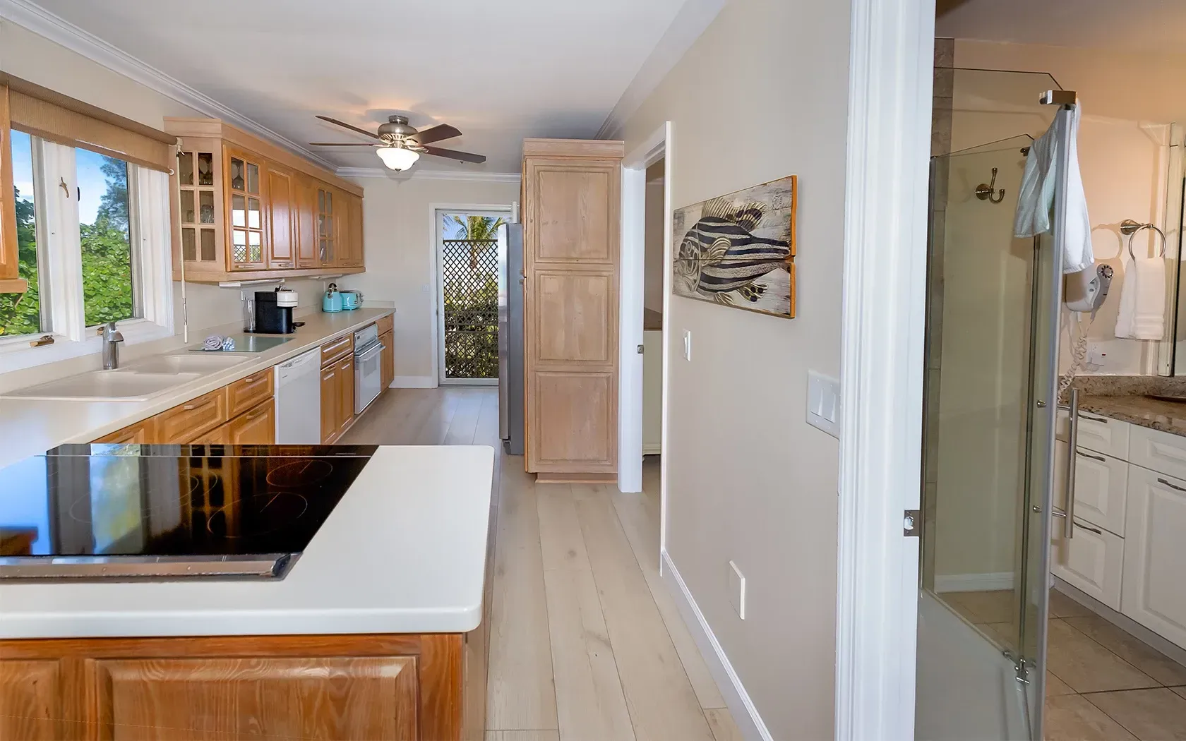 A kitchen with a stove top oven and a walk in shower.