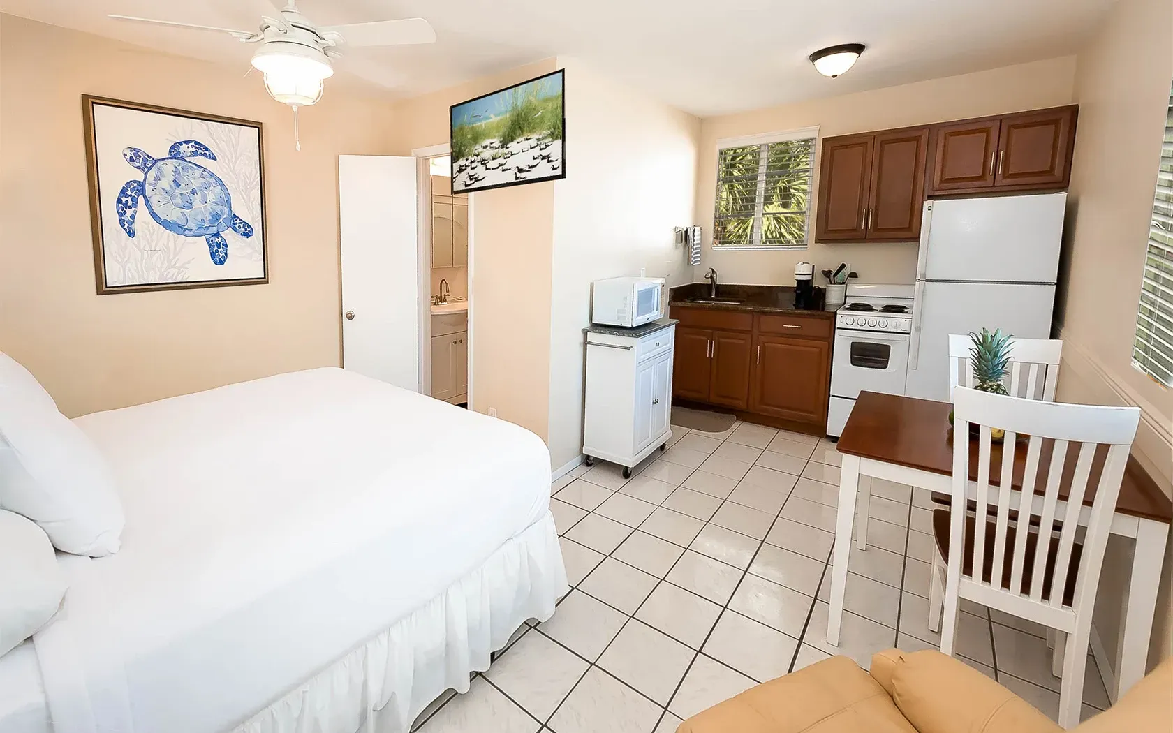 A hotel room with a bed , table , chairs and a kitchen.