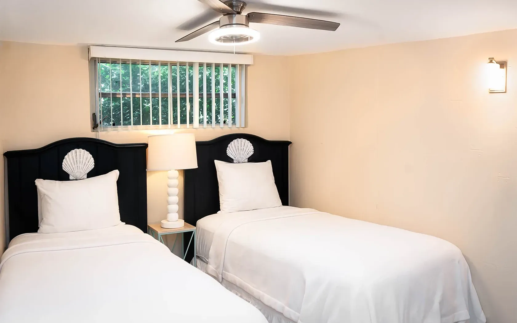 A bedroom with two twin beds and a ceiling fan.