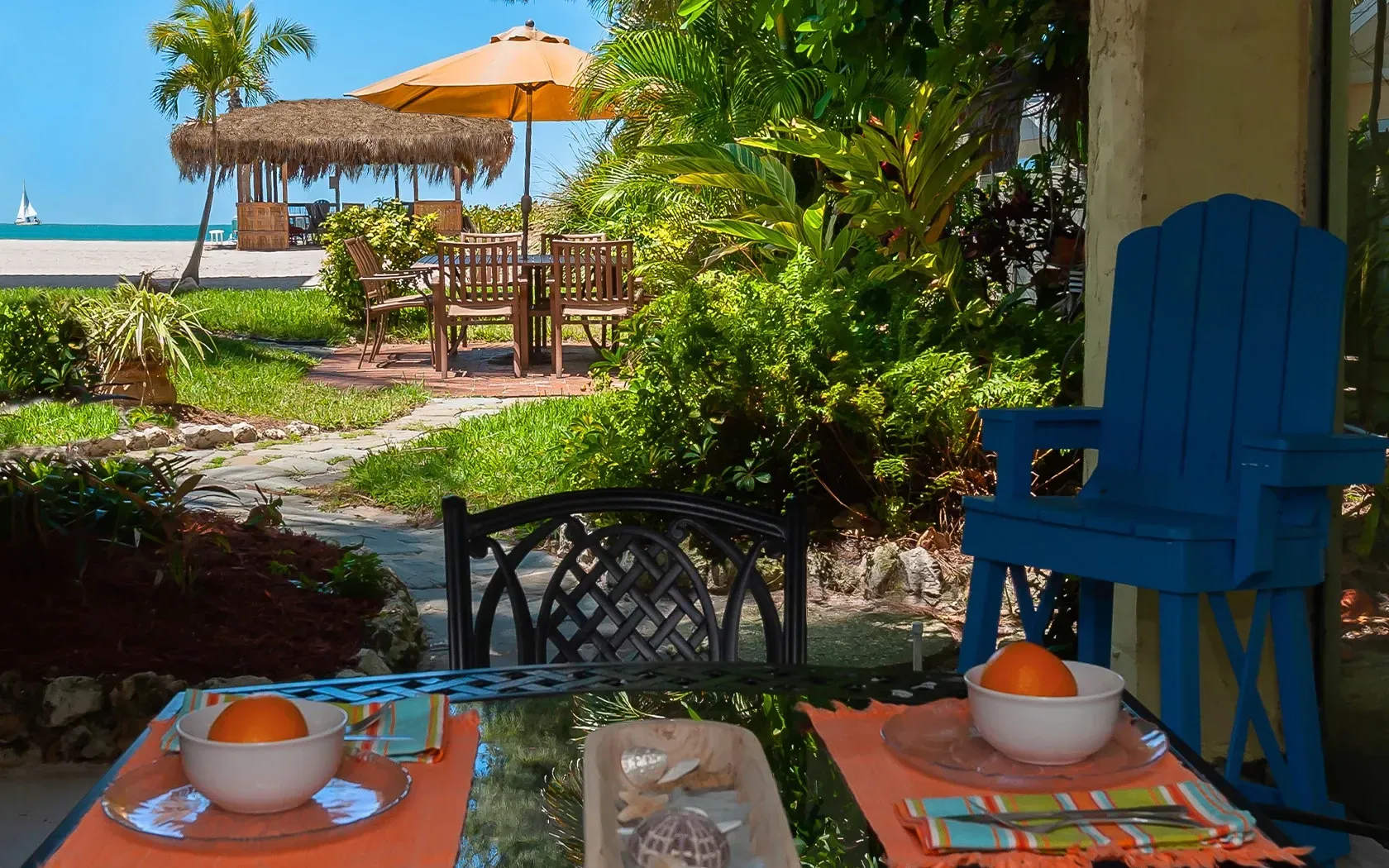 A table and chairs on a patio with a view of the ocean.